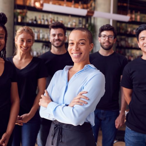 Portrait,Of,Female,Owner,Of,Restaurant,Bar,With,Team,Of